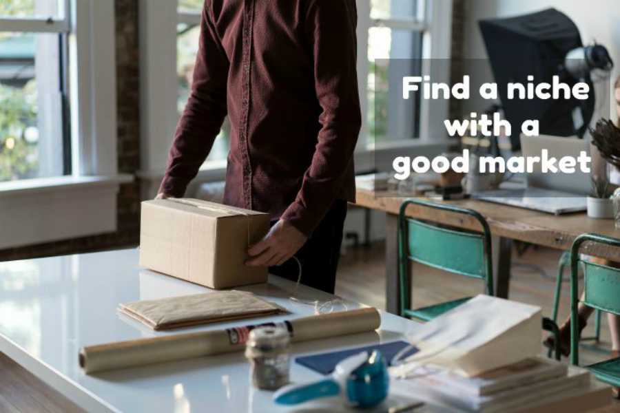 Man packing box at desk with workspace items; "Find a niche with a good market" text overlay.