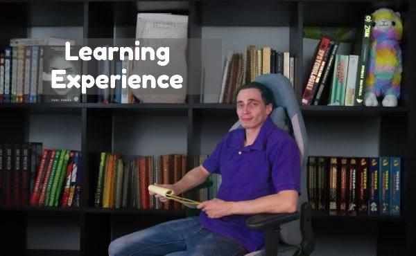 A man comfortably sitting in a chair with an open book in front of him.