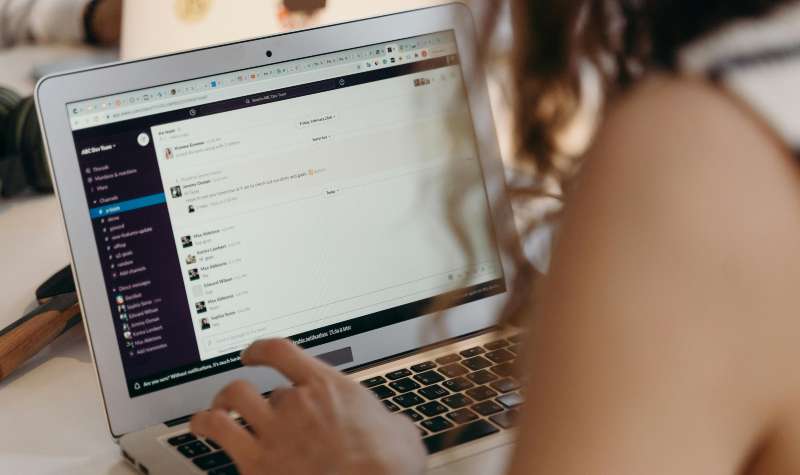 A person using a laptop with an email interface open.