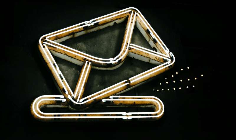 Neon envelope icon with glowing lines against a dark background.