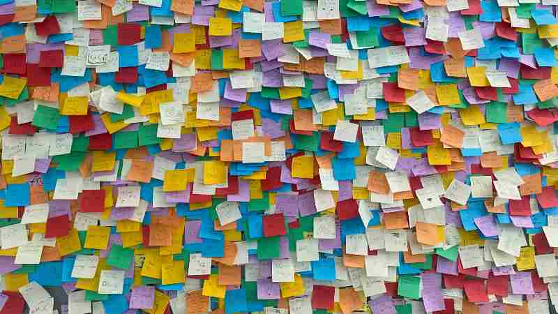 Colorful sticky notes densely packed on a wall.