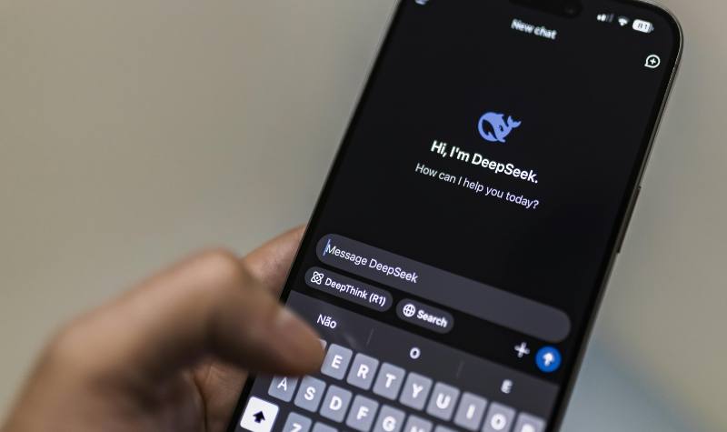 A hand holding a smartphone with an AI chatbot interface.